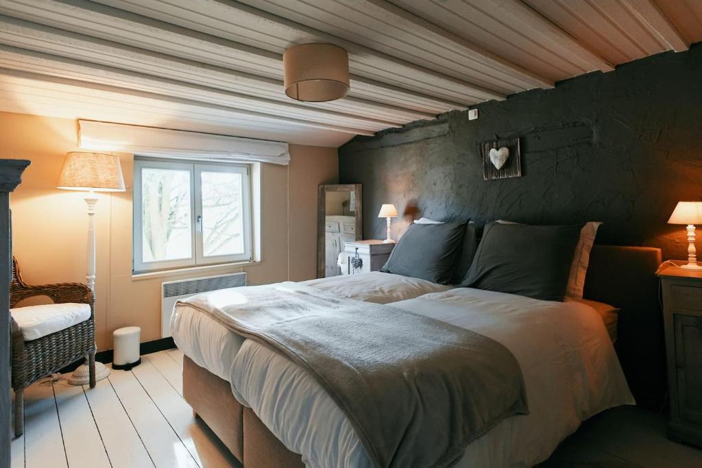 a bedroom with a large bed and a window at Le Petit Gretedar in Malmedy