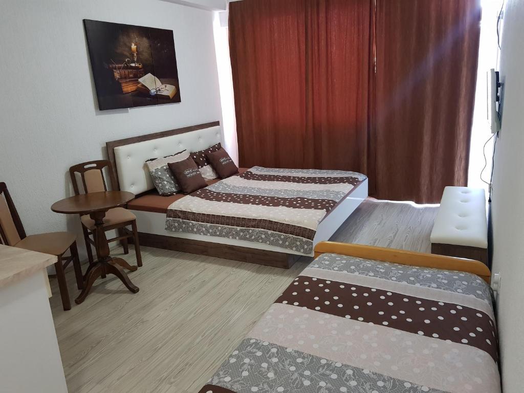 Habitación de hotel con 2 camas y mesa en VIK Apartments, en Vinica