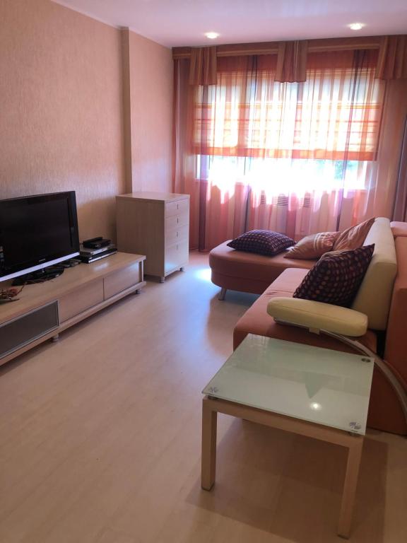 a living room with a couch and a flat screen tv at Apartments Kohtla-Jarve in Kohtla-Järve