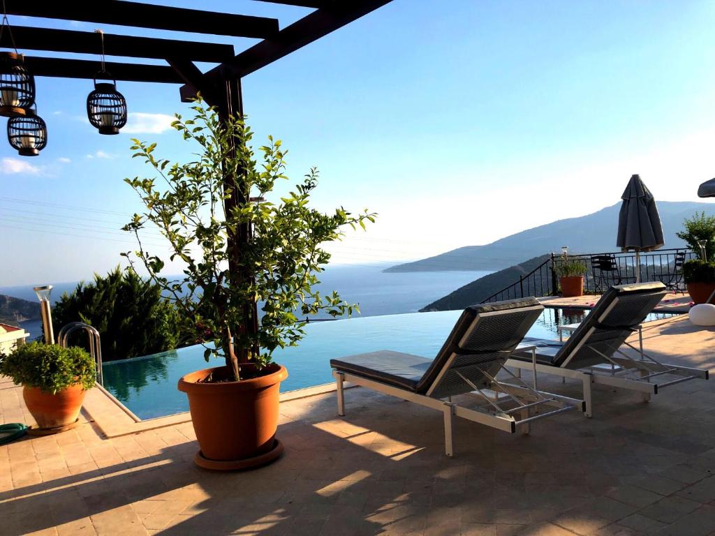Un patio con mesa y sillas y una piscina. en Villa Valo, en Kalkan