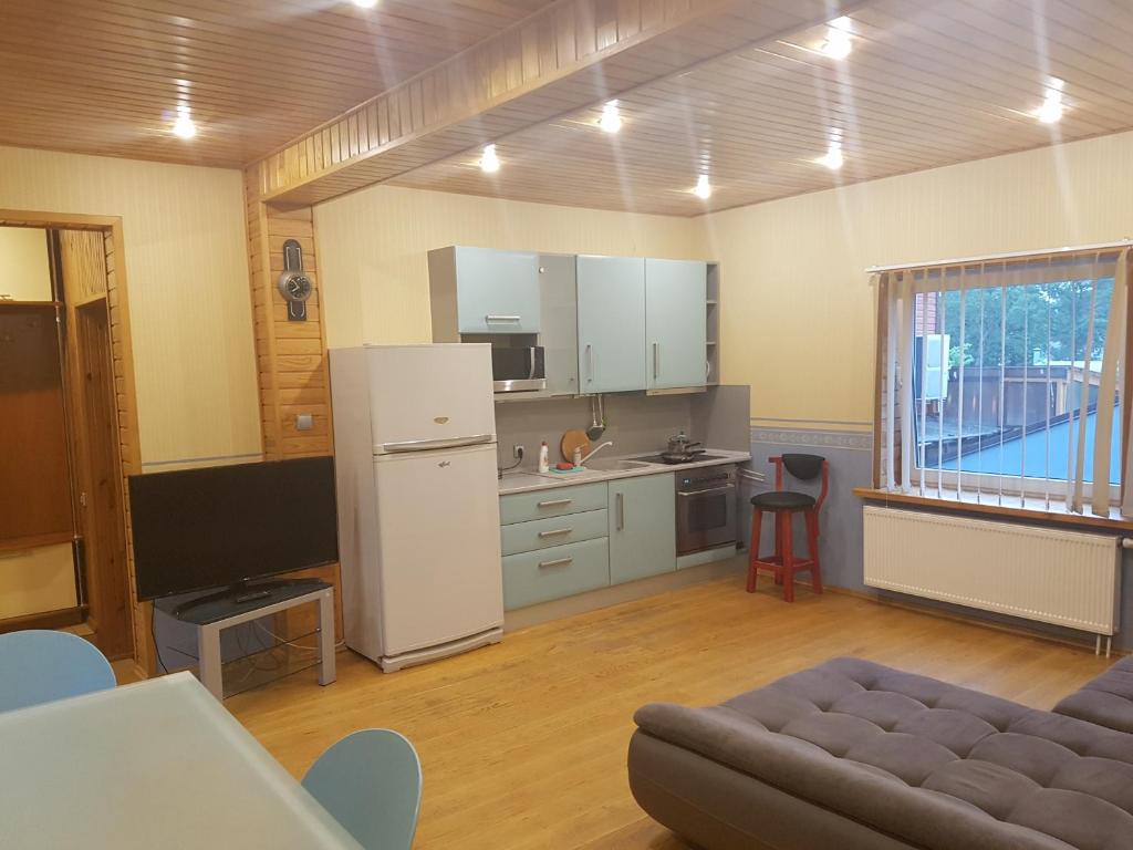 een keuken met een koelkast en een bank in een kamer bij Cozy Home Two Bedroom apartments in Palanga