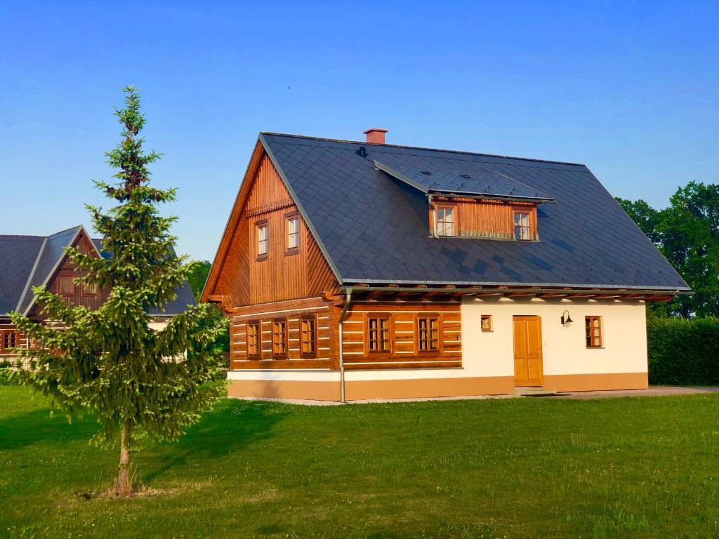 ein großes Holzhaus mit schwarzem Dach in der Unterkunft Roubenka Adél in Vrchlabí