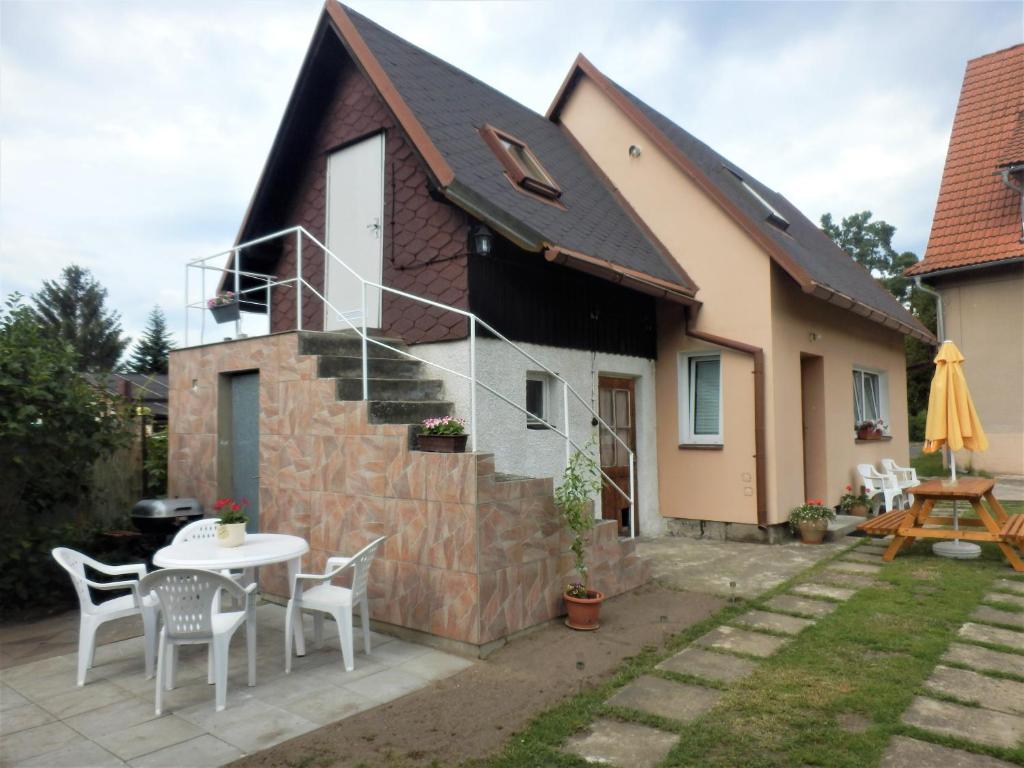 ein Haus mit einem Tisch und Stühlen im Hof in der Unterkunft Podkrovní apartmán v Zátiší in Doksy