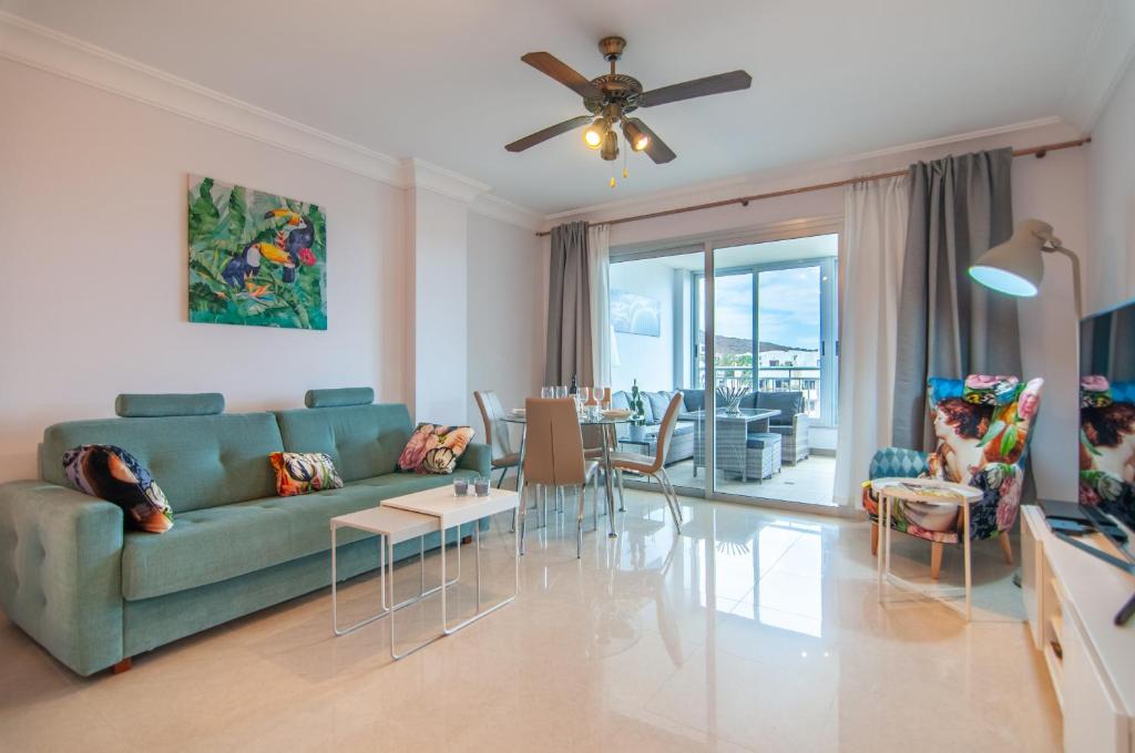 sala de estar con sofá verde y comedor en San Remo 1A036 en Palm-mar