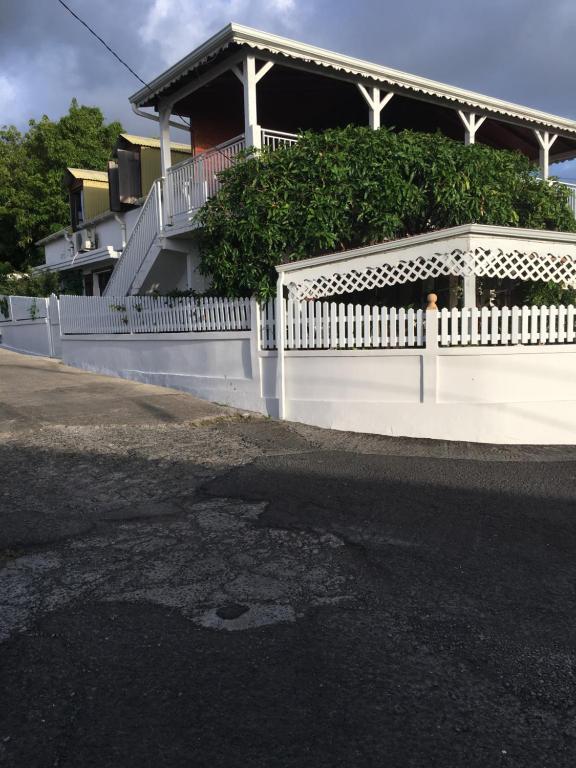 una cerca blanca frente a una casa en Chez Ninette près des sources chaudes, en Bouillante