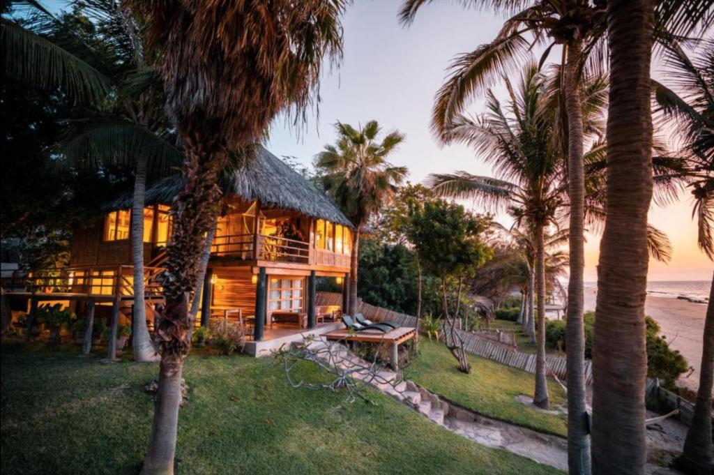 una casa sulla spiaggia con palme di Coco Ne a Máncora