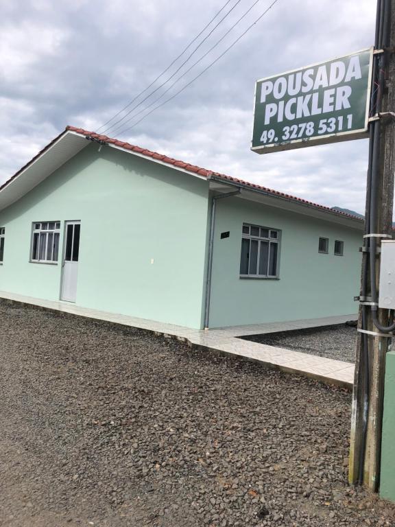 a white building with a sign in front of it at Pousada Pickler in Urubici