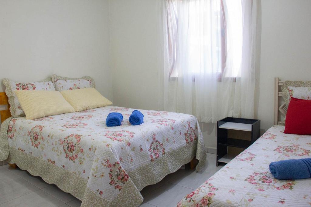 Un dormitorio con dos camas con zapatos azules. en Cantinho Do Sossego, en Canela