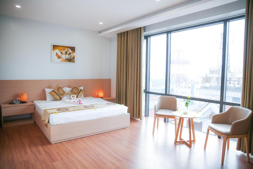 - une chambre avec un lit, une table et des chaises dans l'établissement Long Anh Hotel, à Thanh Hóa