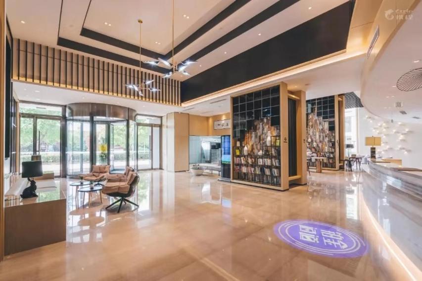 a large room with a lobby with a table and chairs at Atour Hotel Xiasha Branch in Hangzhou