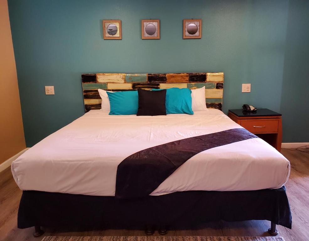 a bedroom with a large bed with blue walls at PineCrest Inn & Suites in Flagstaff