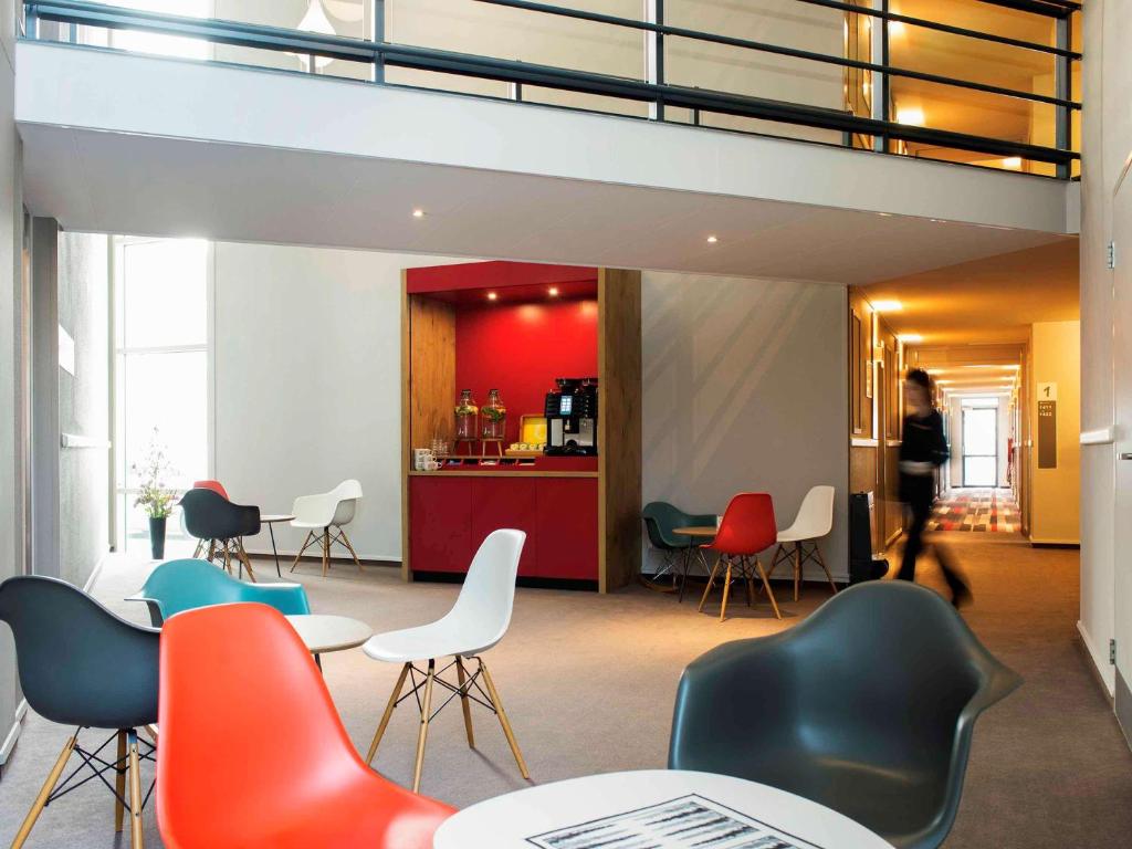 a group of chairs and tables in a room at Ibis Schiphol Amsterdam Airport in Badhoevedorp