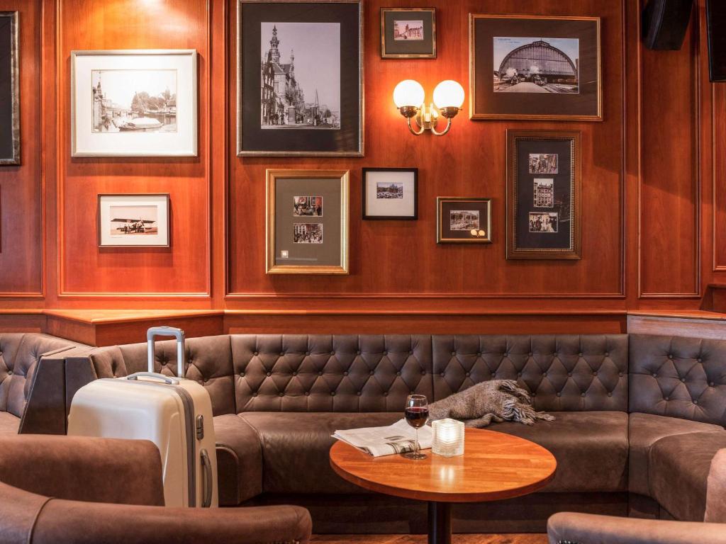 a restaurant with a couch and a table with a suitcase at Ibis Schiphol Amsterdam Airport in Badhoevedorp