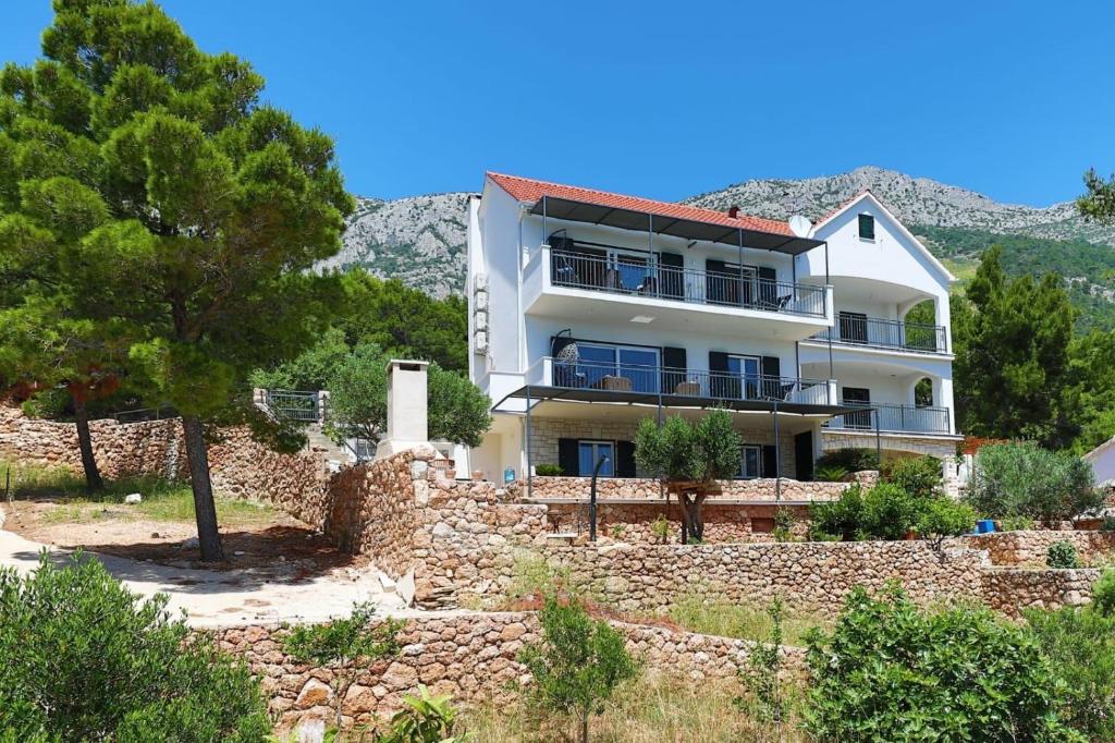 a building on a hill with a stone wall at REDSTONE luxury apartments in Hvar