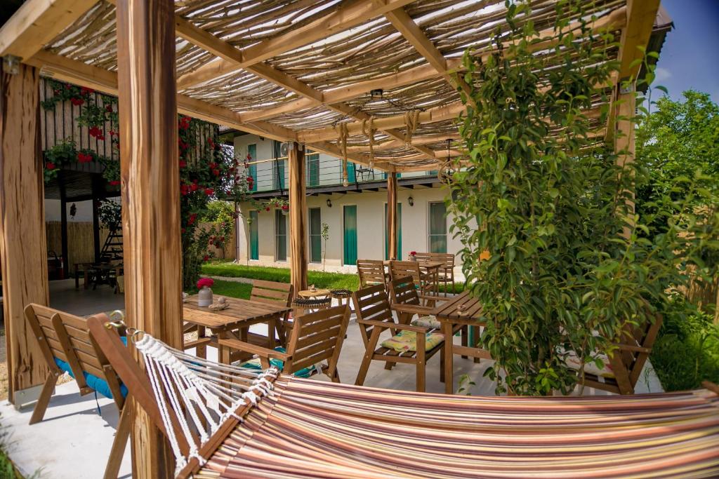 a hammock on a patio under a wooden pergola at Neata Vama Veche in Vama Veche