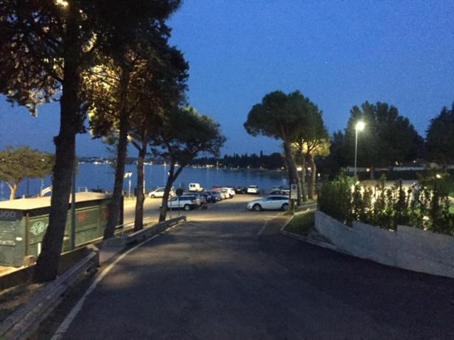 a parking lot with cars parked next to the water at Hotel La Favorita in Peschiera del Garda