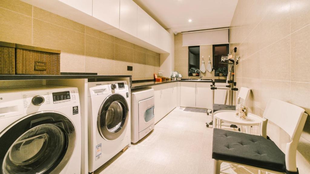 a laundry room with a washer and dryer at Atour Hotel Wuhan Changqing Road Branch in Wuhan