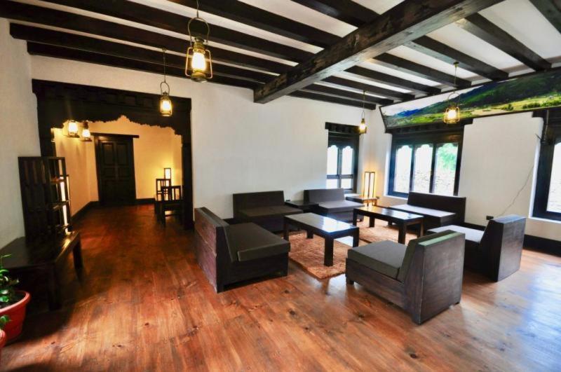 sala de estar amplia con mesa y sillas en The Village Lodge Bumthang, en Bumtang Tang