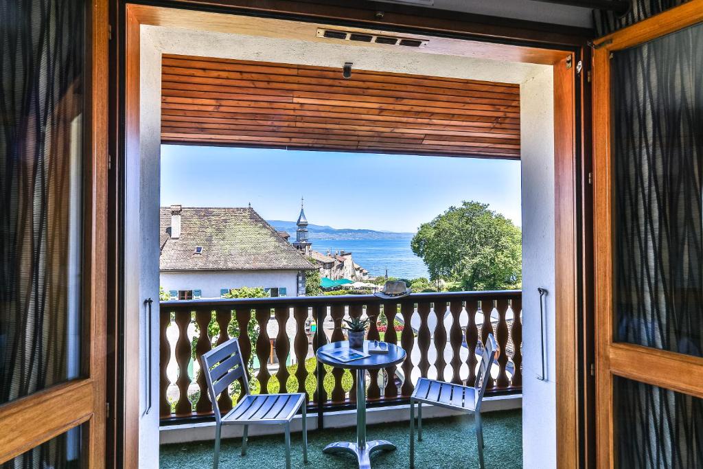 a view from a balcony with a table and chairs at Le Pré de la Cure in Yvoire