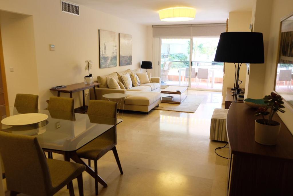 uma sala de estar com um sofá e uma mesa em luxury modern apartment with terrace, pool and garage! em Marbella
