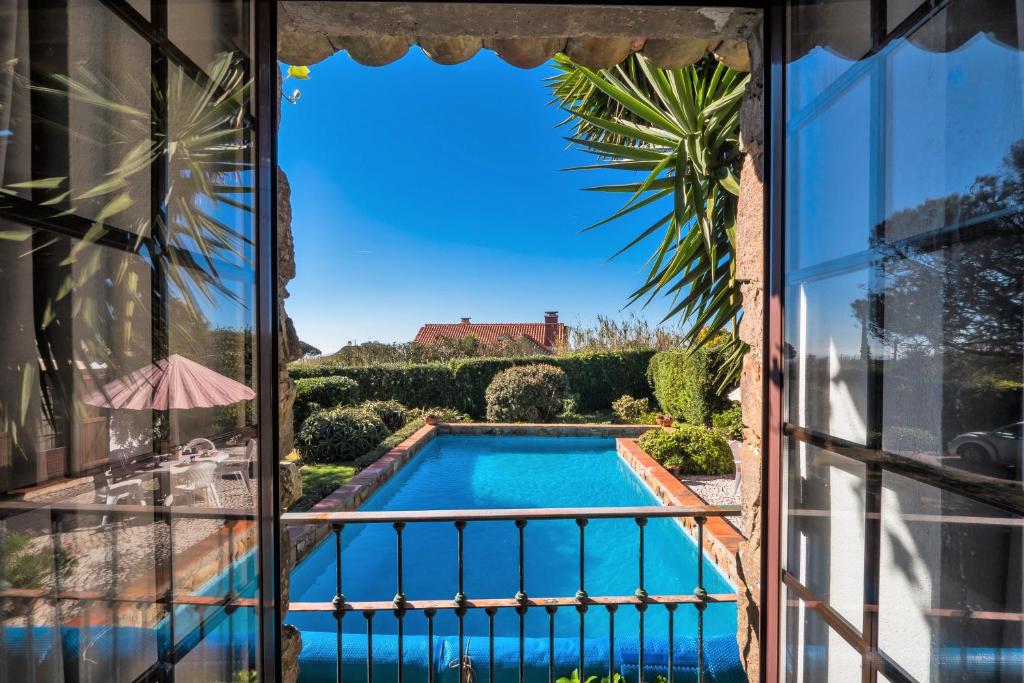 Blick auf den Pool aus dem Fenster in der Unterkunft Casa da Corredoura in Azoia