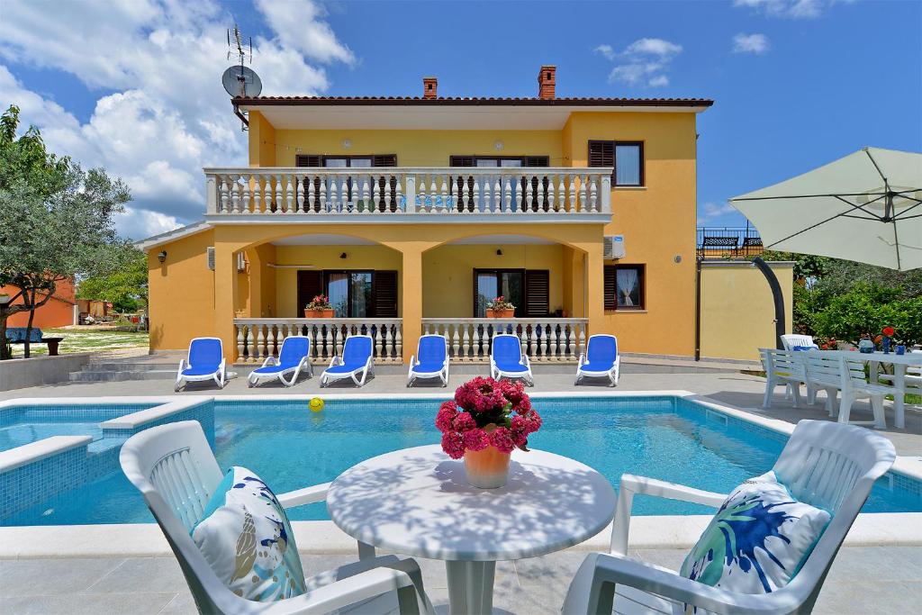 een villa met een zwembad en een tafel en stoelen bij House Smiljana 2059 in Vodnjan