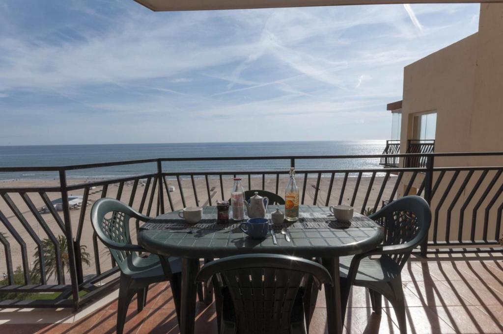 a table on a balcony with a view of the ocean at Ondina in Gandía
