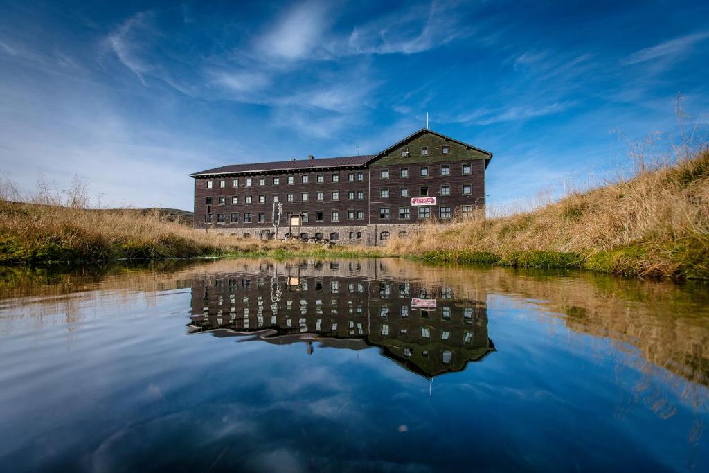 a building sitting on the side of a river at Luční bouda in Pec pod Sněžkou