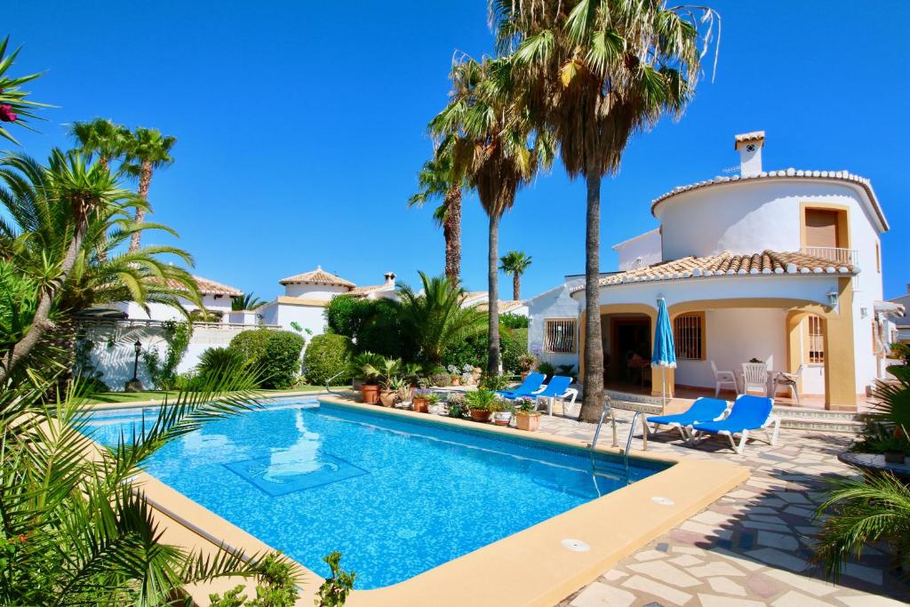 a villa with a swimming pool and palm trees at Els Poblets ER by CARLOSFERIEN in El Verger