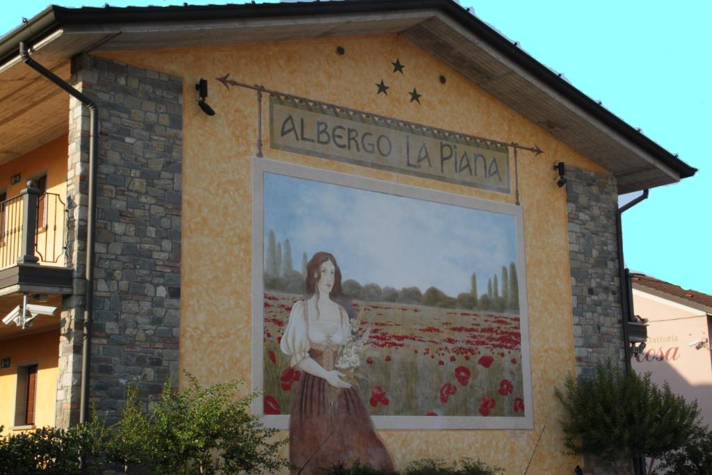un murale di una donna sul lato di un edificio di Albergo La Piana a Ghedi