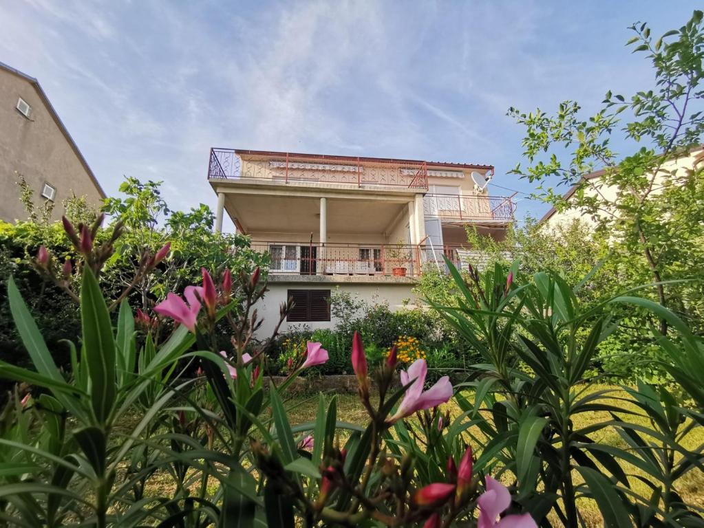 a house in the middle of a garden with flowers at Apartments Kabalin in Novi Vinodolski