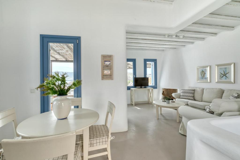 a white living room with a table and a couch at Mykonos Panormos Villas in Mykonos