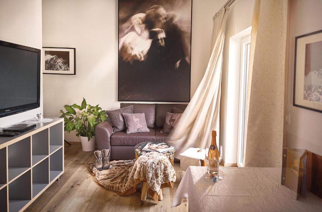 a living room with a couch and a tv at KitzHome City Apartments in Kitzbühel