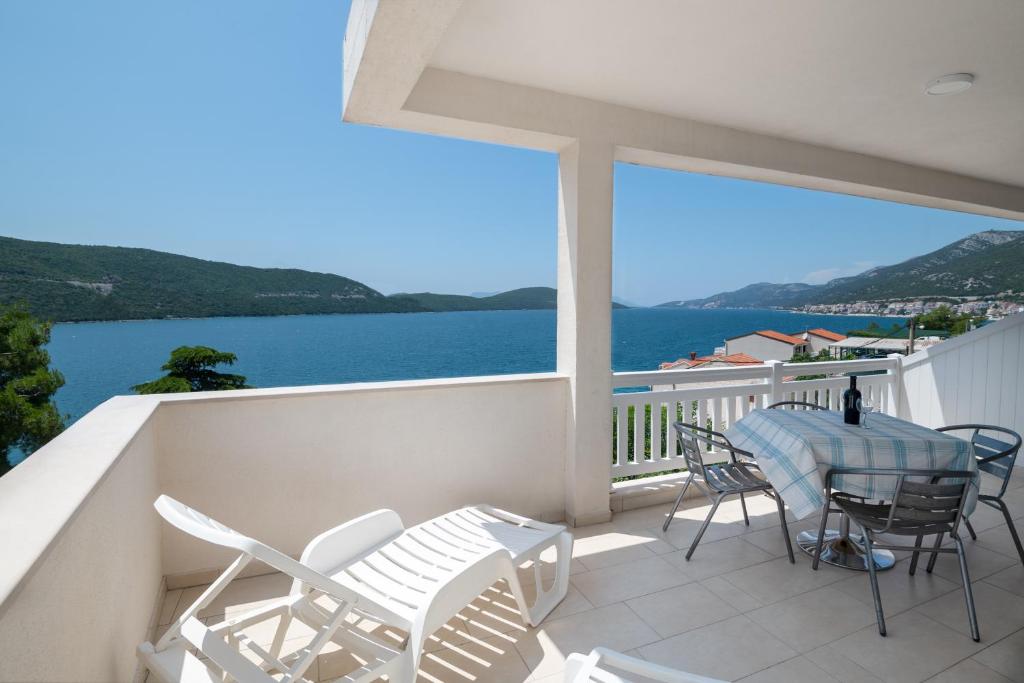 a balcony with a table and chairs and a view of the water at Apartments Lavanda in Neum