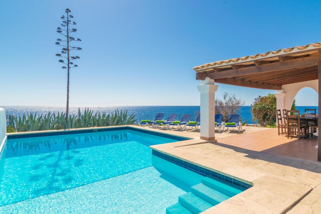 a swimming pool in a villa with a view of the ocean at Villa Sol Naixent in Cala Ferrera