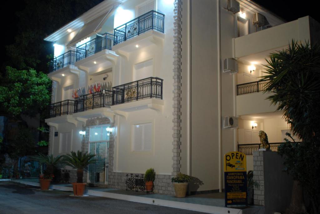 a white apartment building with a balcony at night at 85 m² Apartments New Panorama (under new management) in Paralio Astros