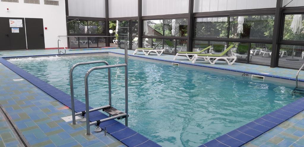 una piscina en un edificio con sillas en VVF Collonges-la-Rouge en Collonges