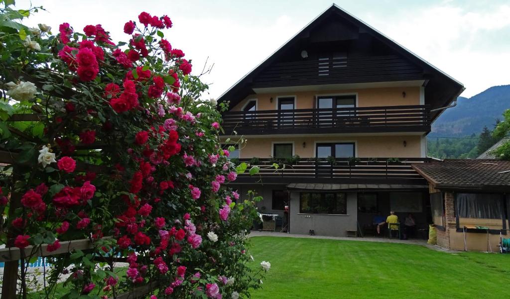 une maison avec un bouquet de fleurs devant elle dans l'établissement Apartmaji Gorenc, à Bohinj