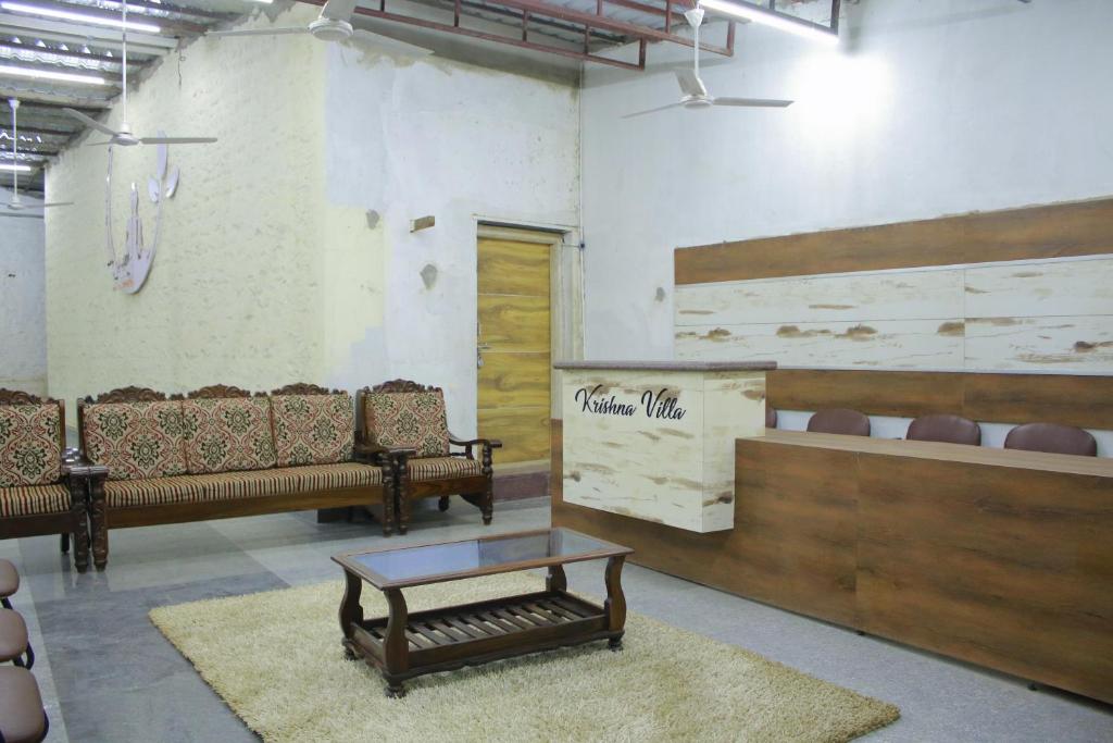 a waiting room with benches and a coffee table at Krishna Villa in Badami
