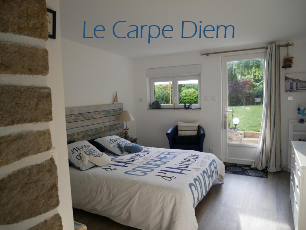 a white bedroom with a bed with a cape dream sign at Le Carpe Diem in La Forêt-Fouesnant