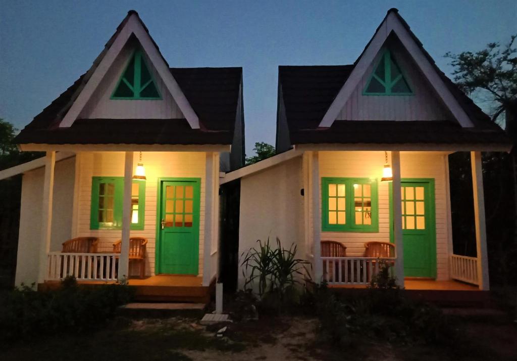 una casa con puertas y ventanas verdes por la noche en Balakosa Gili Meno Bungalow en Gili Meno