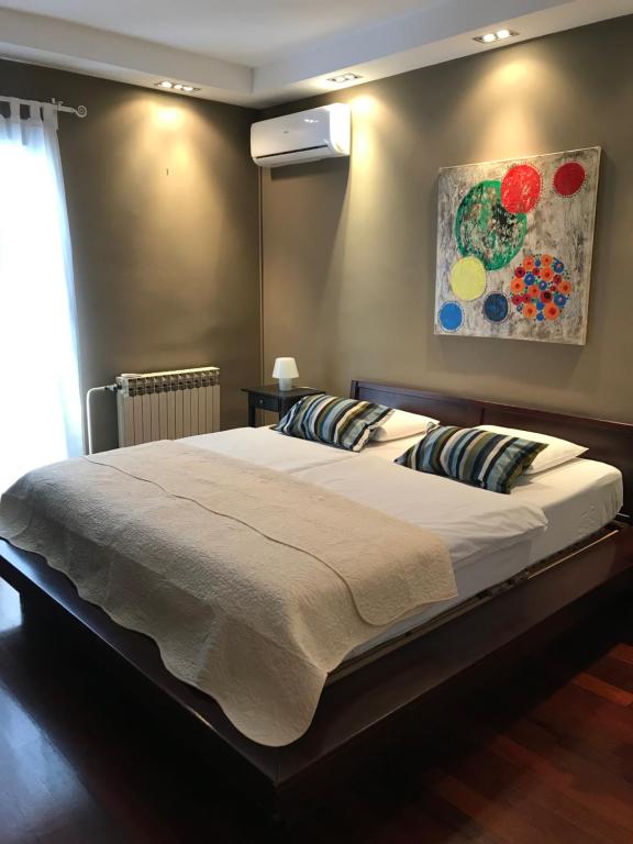 - une chambre avec un grand lit orné d'une peinture murale dans l'établissement Apartment Francos, à Primošten