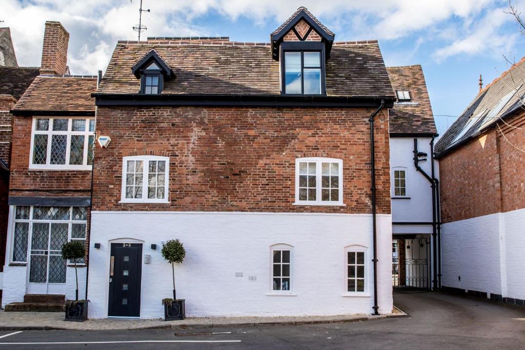 une grande maison en briques avec une façade blanche dans l'établissement Little George, à Henley in Arden