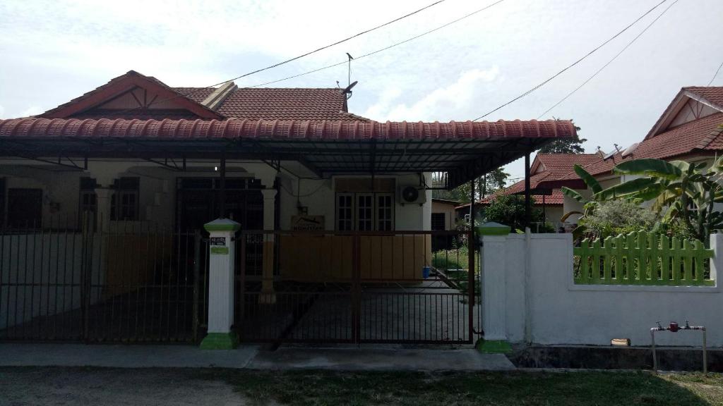 una casa con una puerta y una valla en Syahril homestay, en Dungun