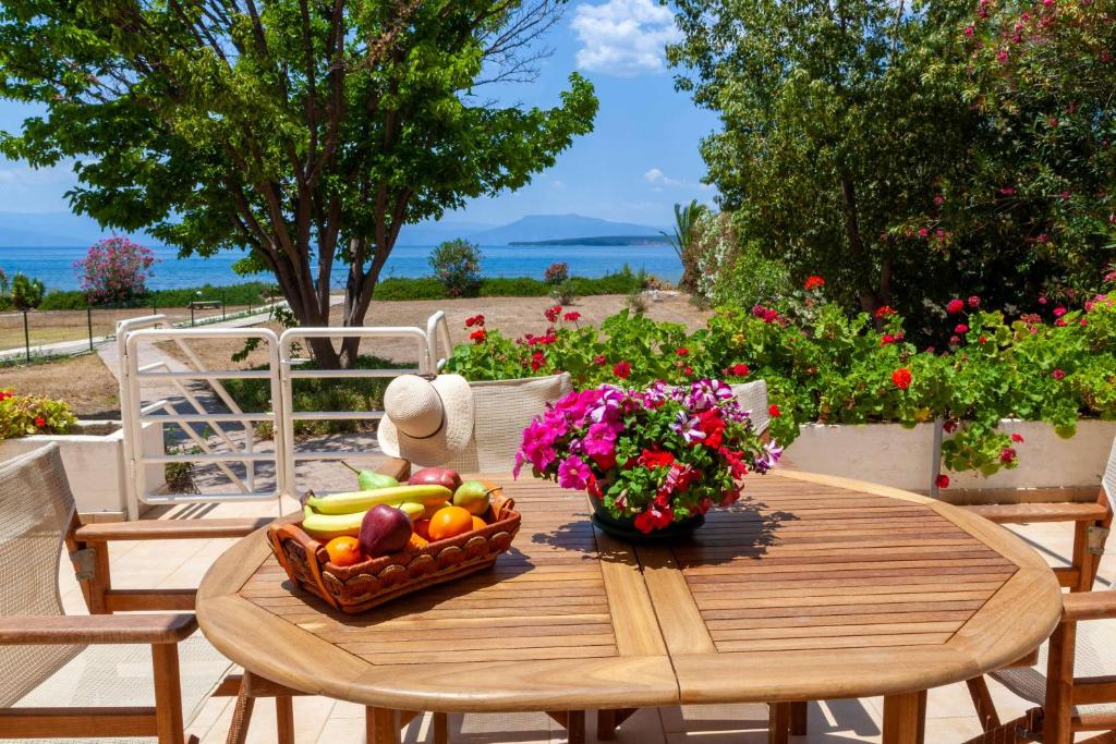 Paralía IríonにあるVillaEvaNafplionの木製テーブル(フルーツと花のバスケット付)