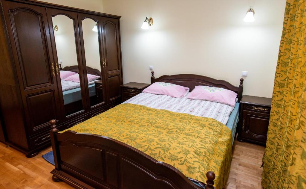 a bedroom with a bed with a dresser and a mirror at CASA DE SUB MAGURA in Simeria