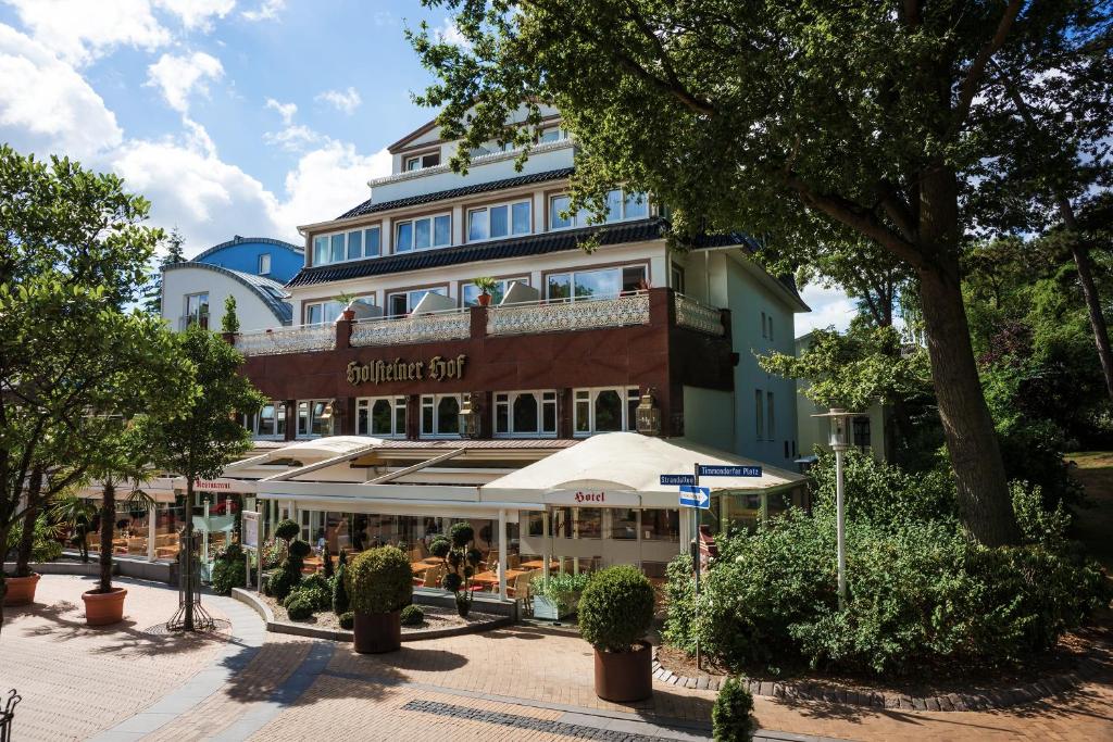 ein Gebäude mit einem Café davor in der Unterkunft Hotel Holsteiner Hof GmbH in Timmendorfer Strand