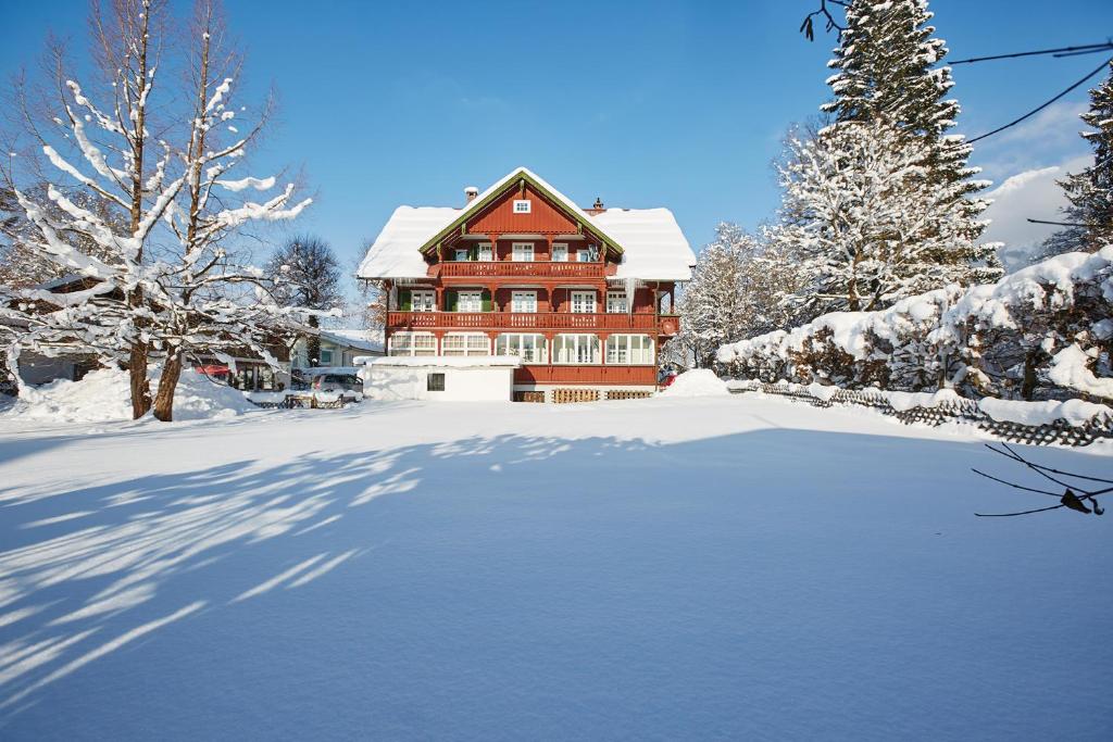 ein großes Haus mit Schnee auf dem Boden in der Unterkunft Haus Castell in Oberstdorf