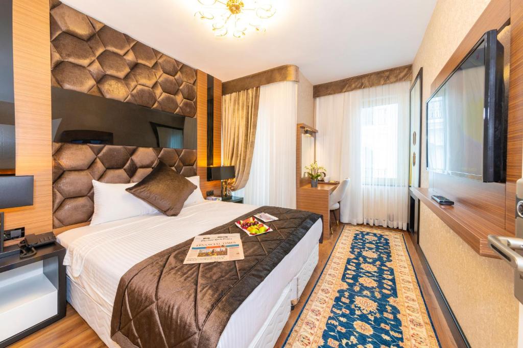 Cette chambre comprend un grand lit et un bureau. dans l'établissement Eastanbul Suites, à Istanbul