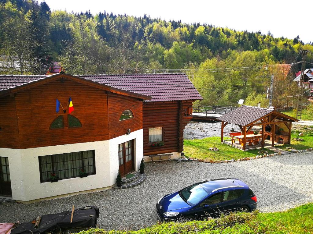 a blue car parked in front of a house at Cabana Rustic Balea in Cîrţişoara